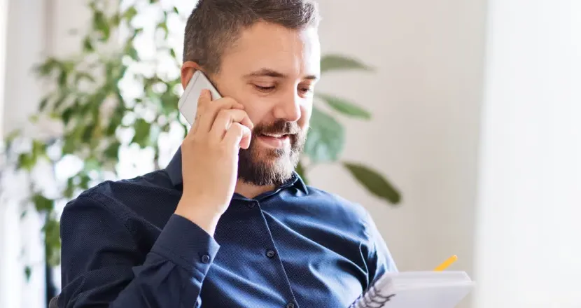 IT Manager Discussing Team Strategy On Phone In Office